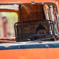 Kleines Mädchen sitz in altem Schrottfahrzeug am Steuer, Madagaskar | Madagascar